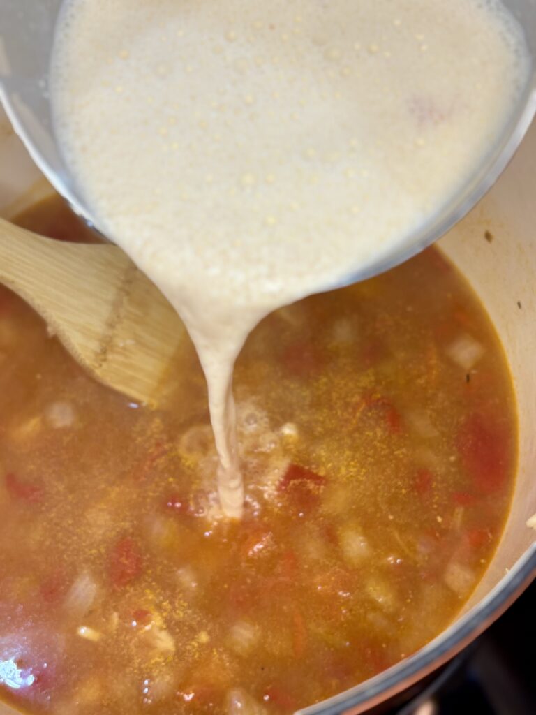 cream cheese and broth mix being poured back in to soup pot