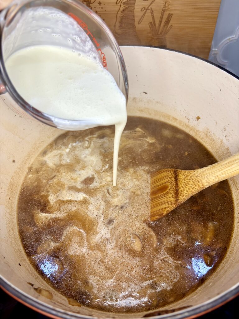 heavy cream being added to soup pot