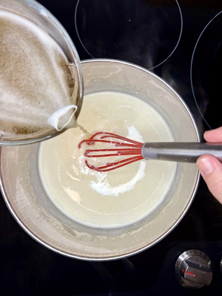  beer being poured in to pot with milk, butter, and flour