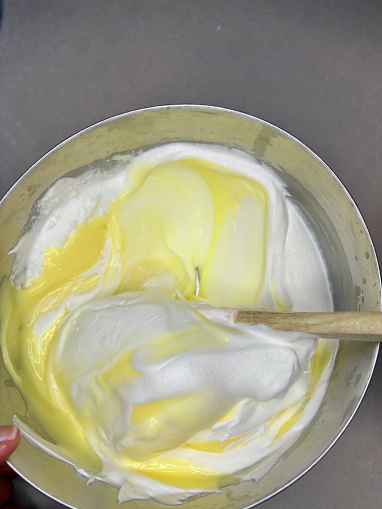 whipped topping being stirred into vanilla pudding