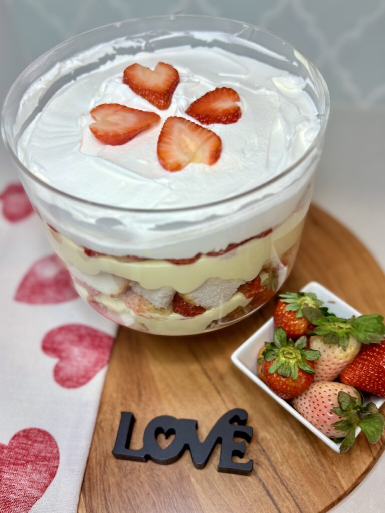 Strawberry Vanilla Trifle on a counter next to a heart towel an bowl of strawberries