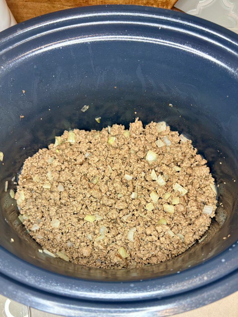 cooked ground beef with onions in a slow cooker 