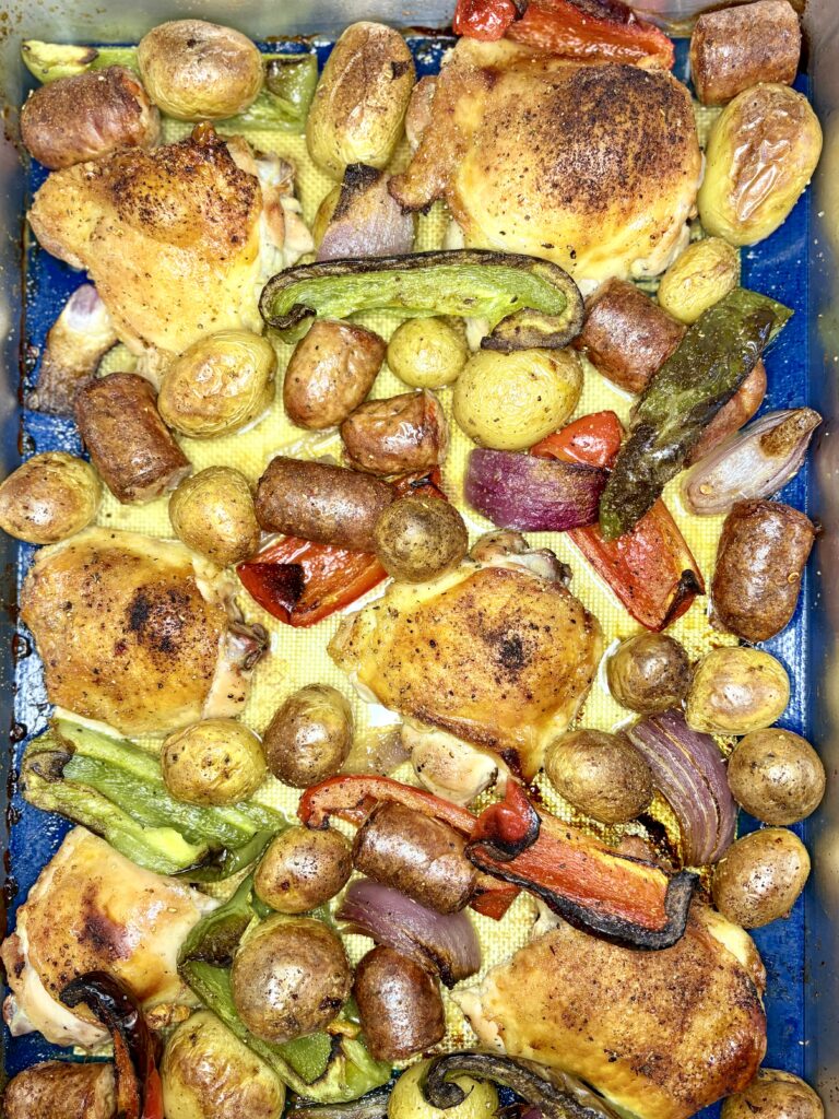 cooked chicken and sausage sheet pan dinner in a deep sheet pan