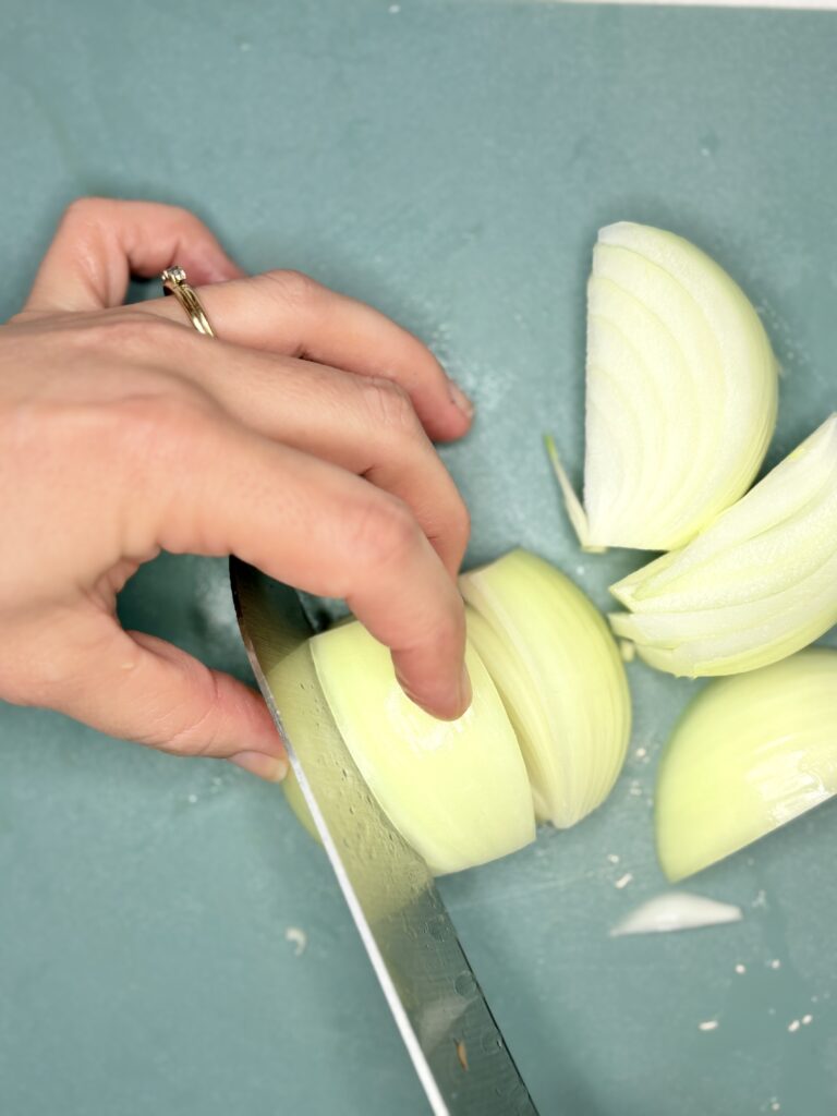 an onion being sliced with a knife