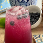 Blueberry and Pineapple Mocktail with fresh blueberries, served over ice in a tall glass, garnished with bubbly soda, perfect for summer refreshment.
