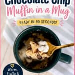 Chocolate chip muffin in a mug with a spoon, ready to eat, on a white wooden surface.