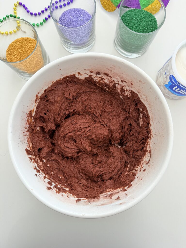 Cake batter and pumpkin puree are mixed in a large bowl on the counter.