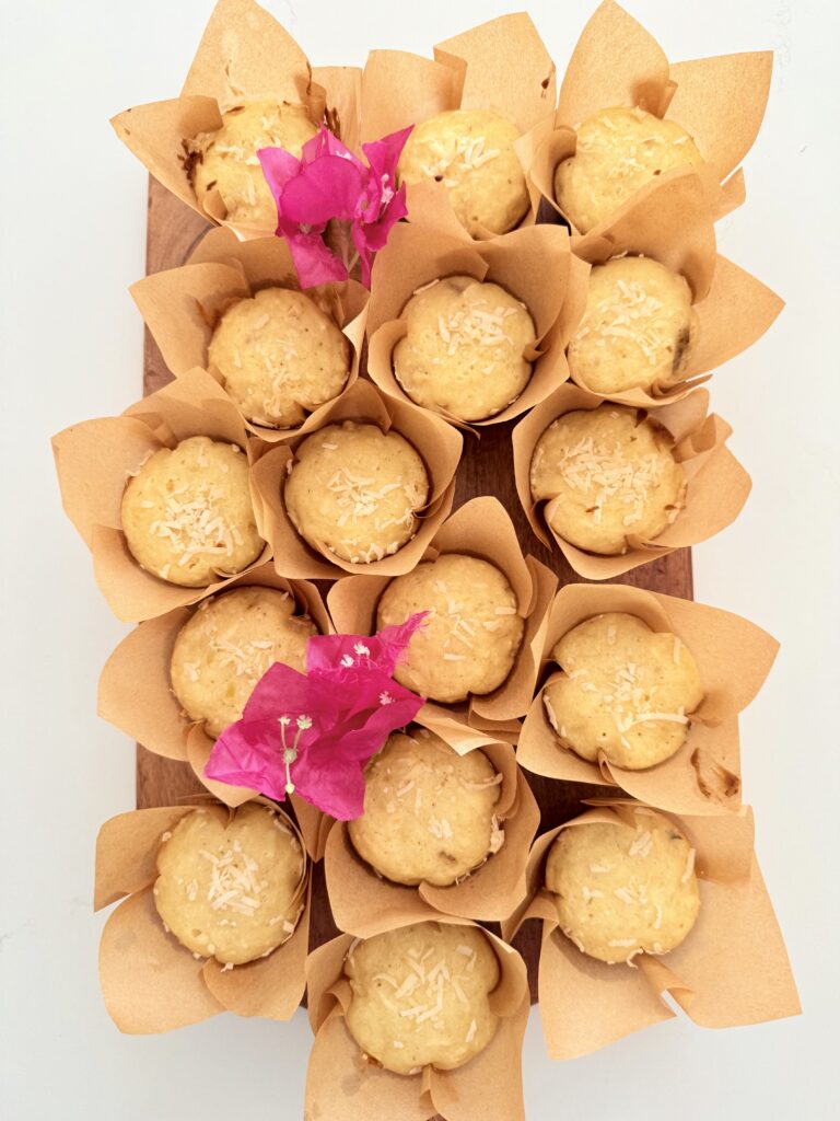 Hawaiin Banana Muffins on a brown cutting board on the counter.