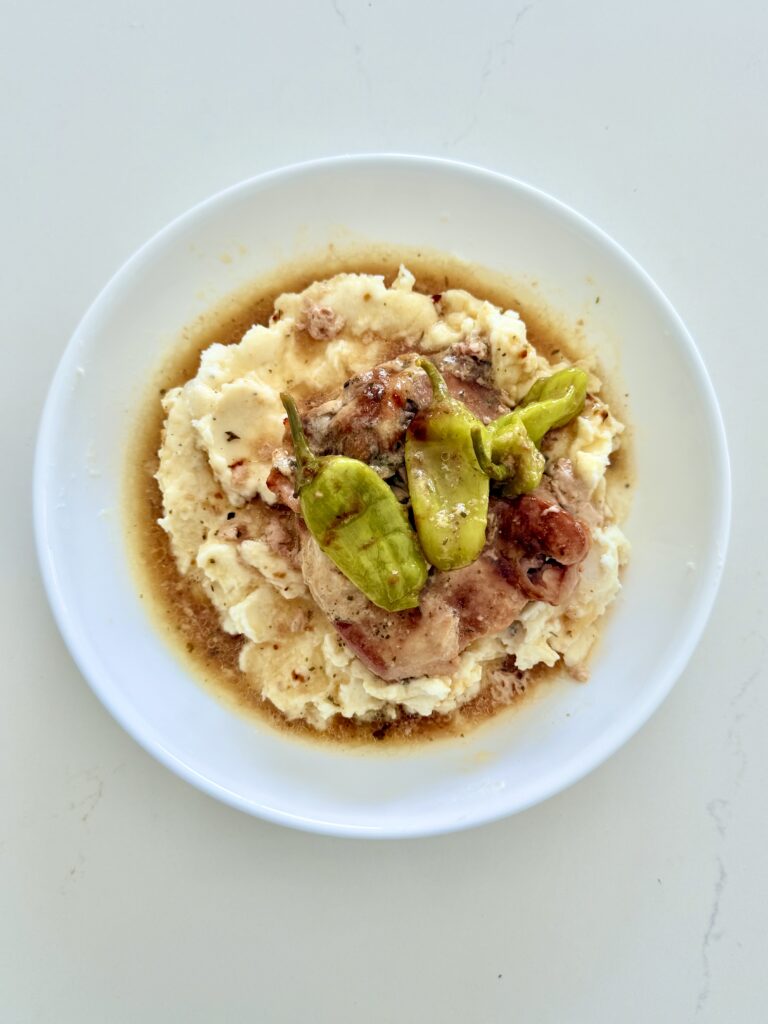 Slow cooker Mississippi chicken on a white plate on the counter.