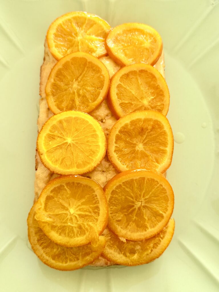 Citrus-lovers cake on a green cake plate on the counter.