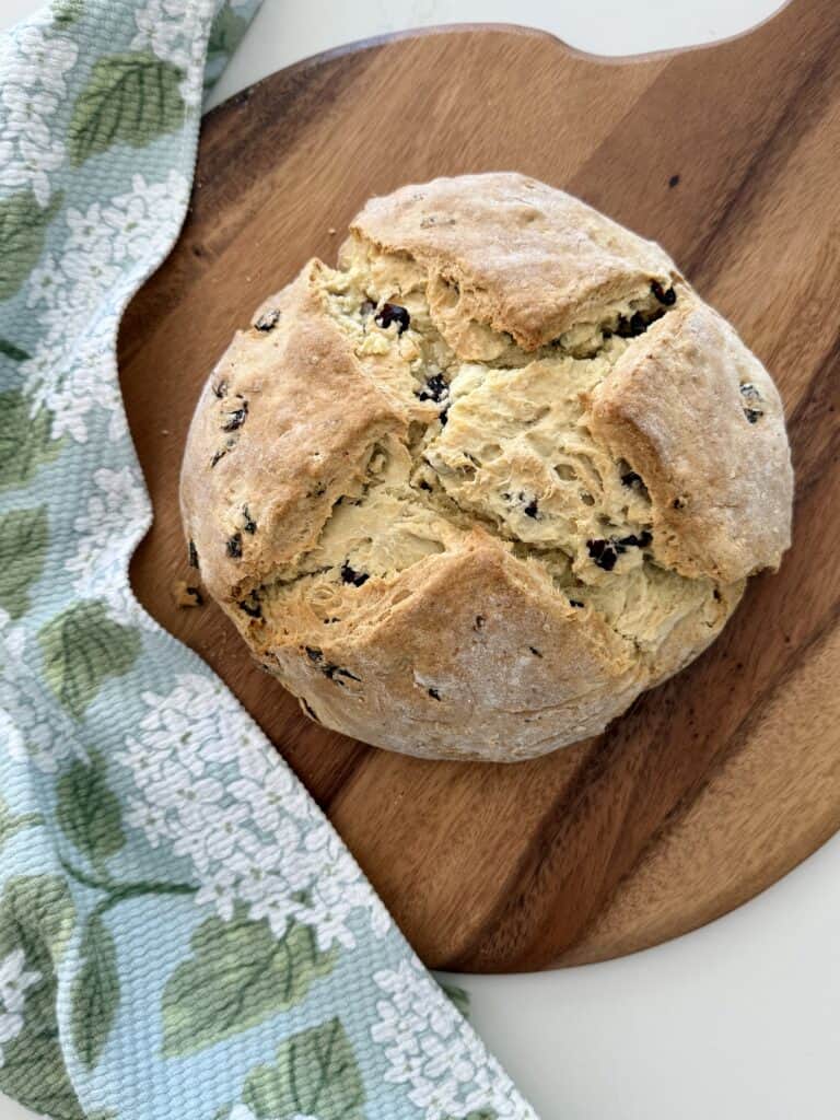 Cranberry Orange Irish soda bread on a brown cutting board.