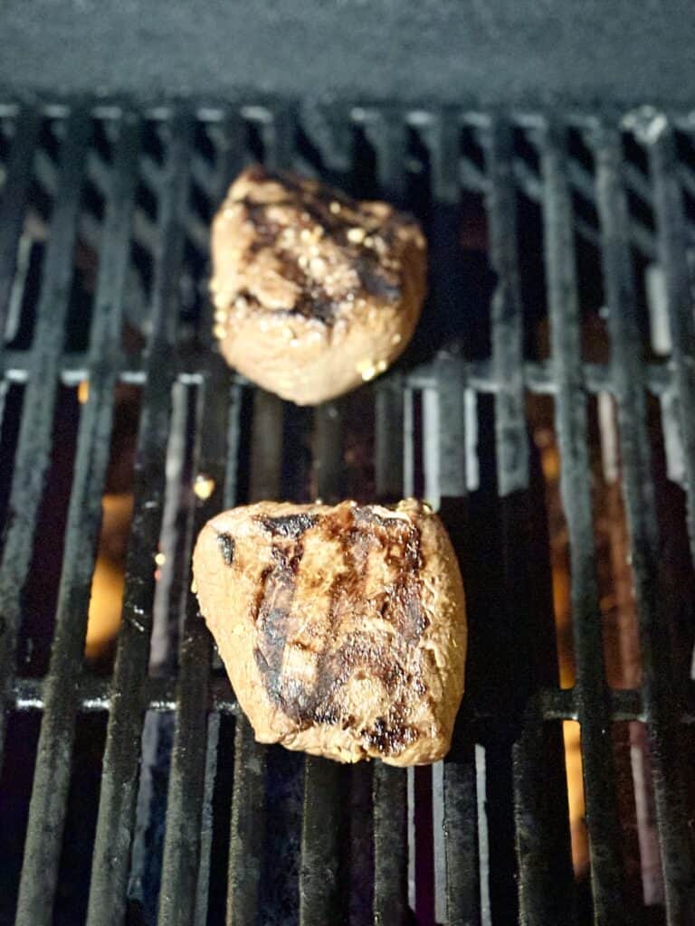 two steaks being grilled