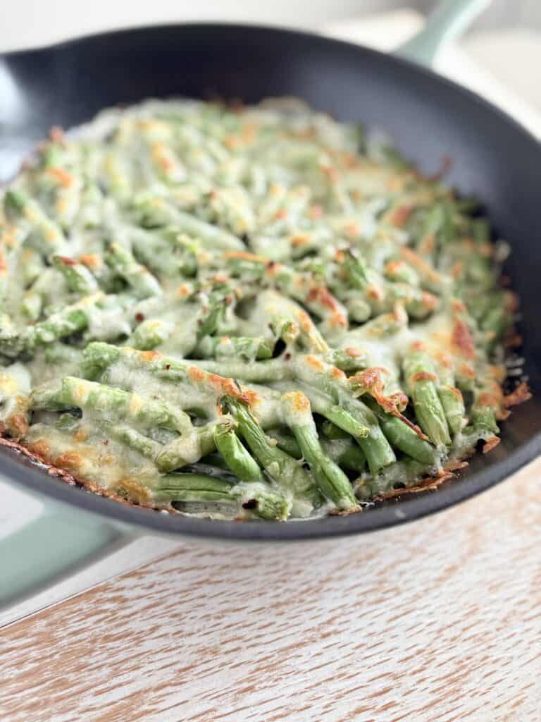 baked cheesy green beans in a skillet