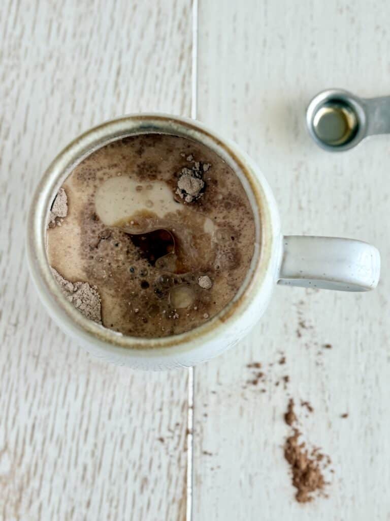 wet ingredients added to a mug with chocolate and pancake mix