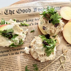 Cream cheese chicken salad sandwiches on sliced apples with fresh greens and herbs, served on newspaper for a casual, healthy lunch or snack. Easy, flavorful, and perfect for meal prep.