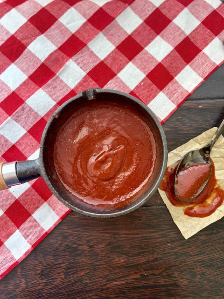 Classic Barbecue sauce in a saucepan on a table with a spoon