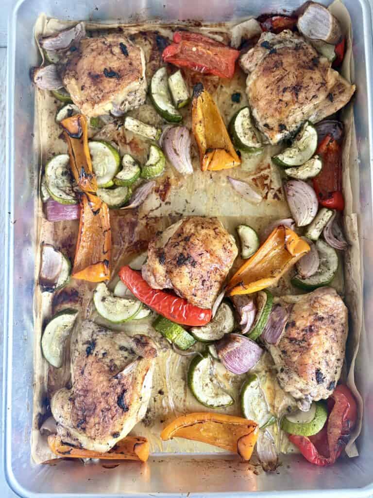 cooked jerk chicken and veggies on a sheet pan