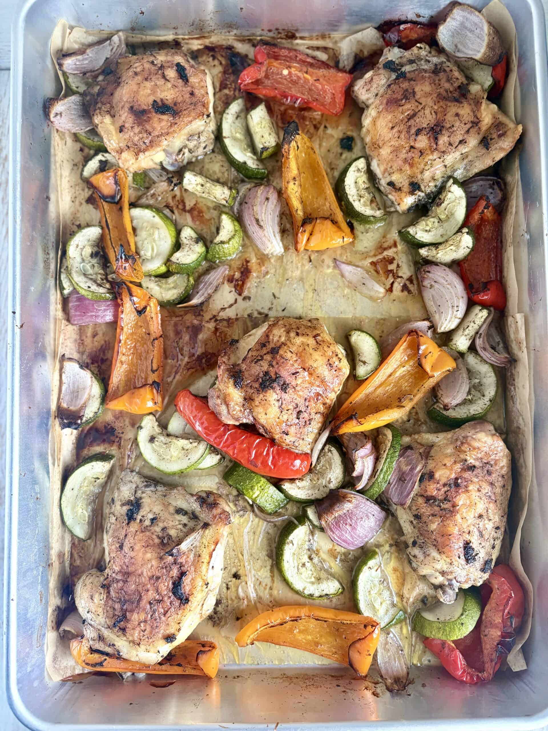 cooked jerk chicken and veggies on a sheet pan