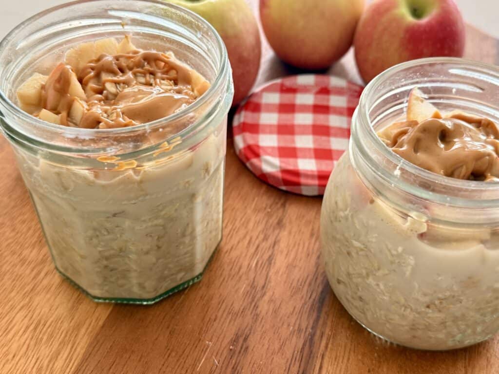 Apple Peanut Butter Overnight Oats on a brown cutting board.