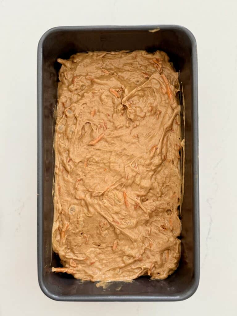 carrot cake batter in a 9x5 inch loaf pan on the counter.