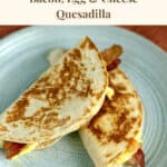 Bacon egg and cheese breakfast burritos on a blue plate, ready to serve.