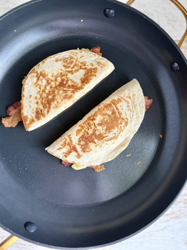 2 quesadillas browning in a skillet on the second side
