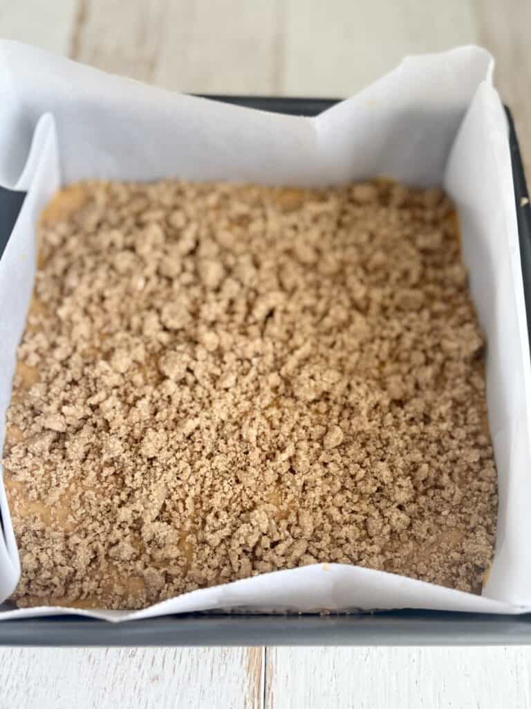 Golden brown streusel topping on dessert in a baking pan, perfect for pumpkin, apple crisp or crumble recipes.