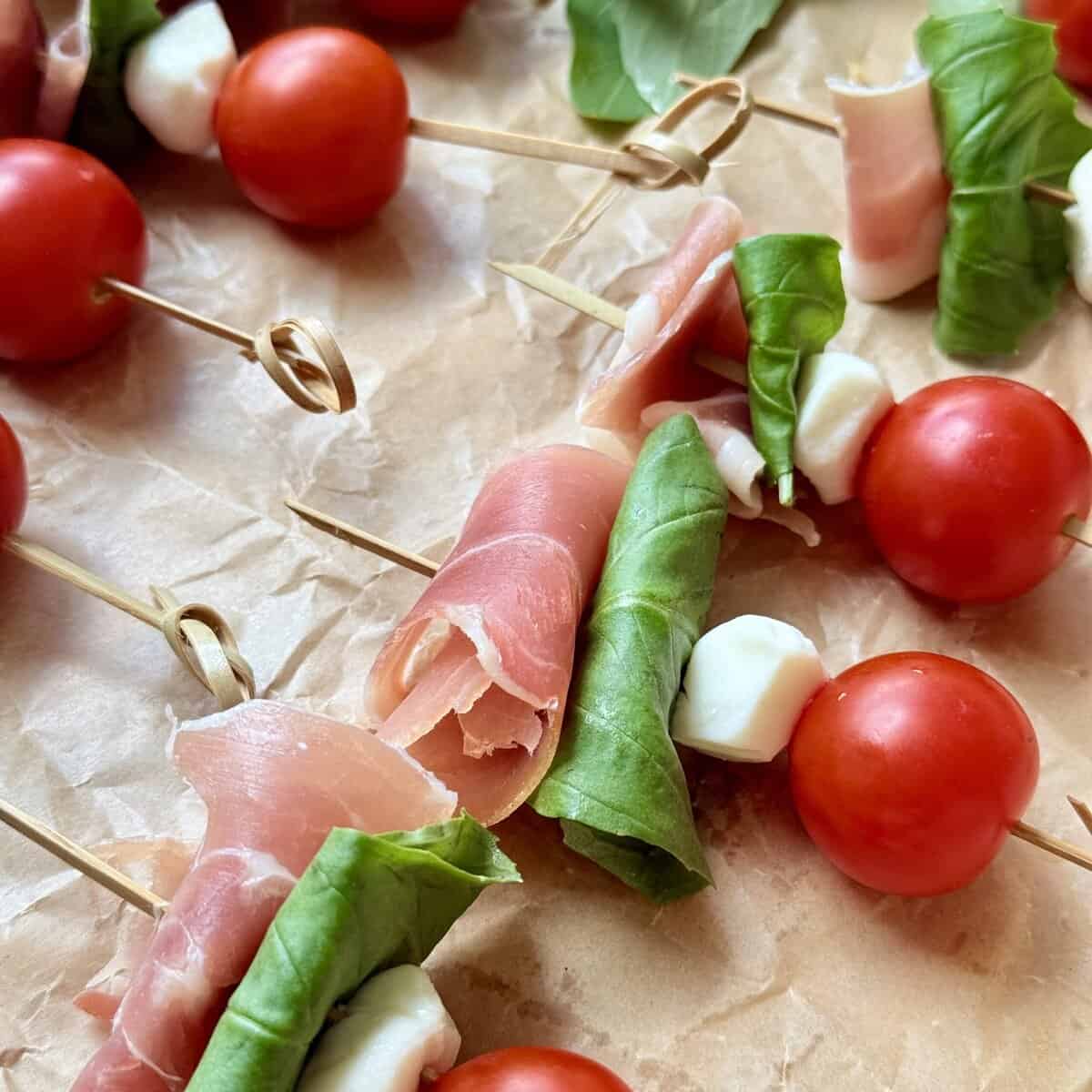 Fresh caprese skewers with cherry tomatoes, mozzarella cheese, basil leaves, and prosciutto, perfect for appetizers, parties, and gatherings. Easy to make and visually appealing for any occasion.