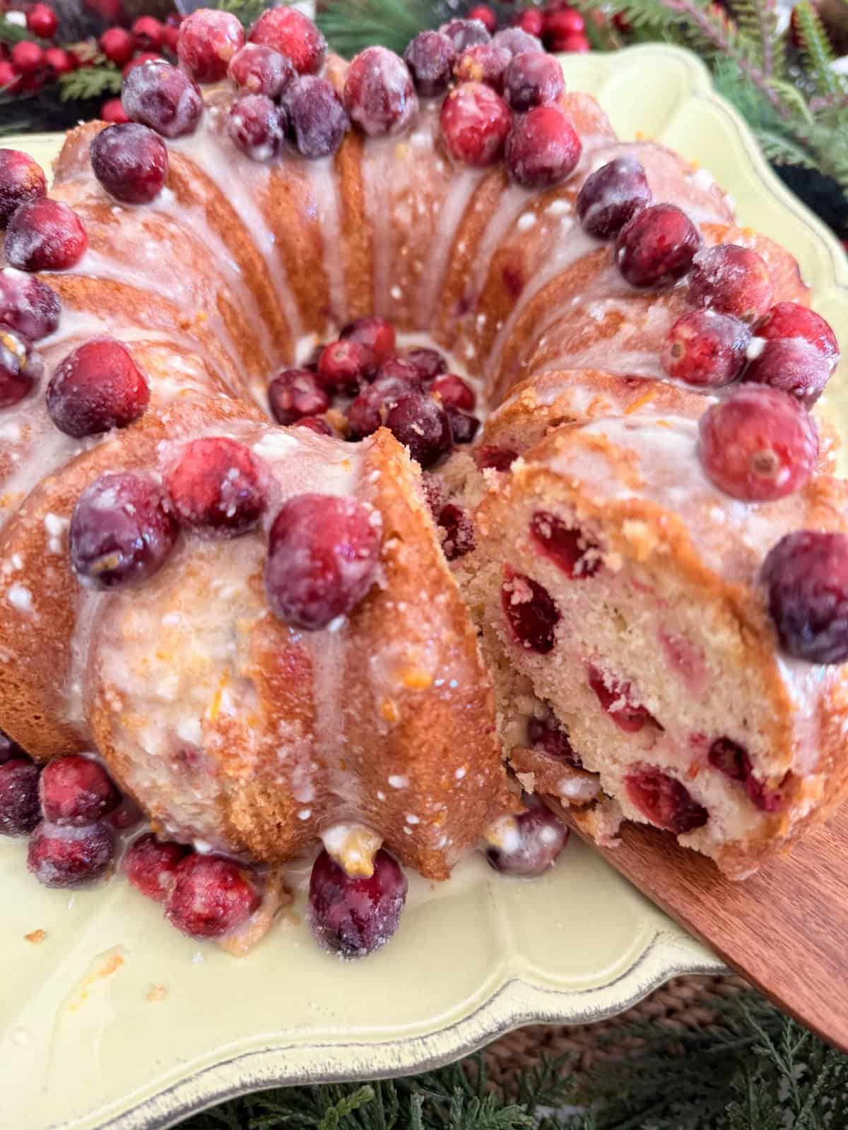 Fresh cranberry coffee cake with icing, topped with whole cranberries, on a decorative plate, ideal for holiday gatherings, featuring a moist crumb and vibrant seasonal fruit.