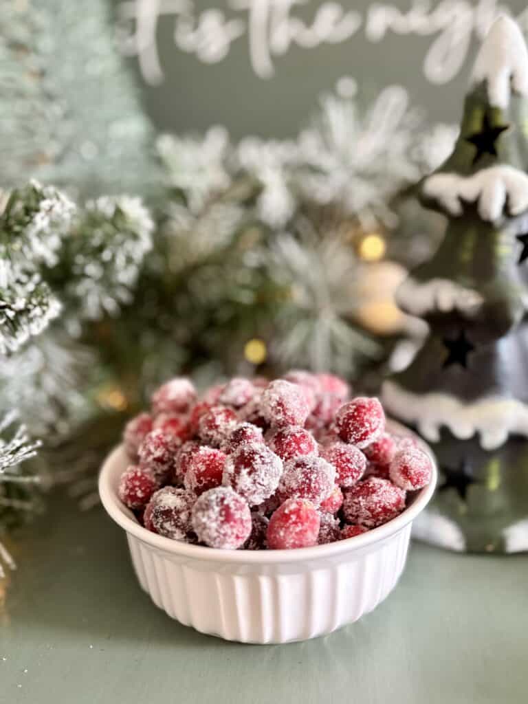 Cranberry holiday dessert in a white ramekin with a Christmas tree and snowy decorations in the background, perfect for a festive holiday celebration.