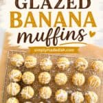 A close-up of freshly baked mini banana muffins with a glossy glaze, arranged on a wire cooling rack. These muffins are moist, flavorful, and topped with a sweet glaze, making them a perfect snack or breakfast option. The image highlights the appealing texture and golden color of the muffins, emphasizing their homemade quality and delicious taste.