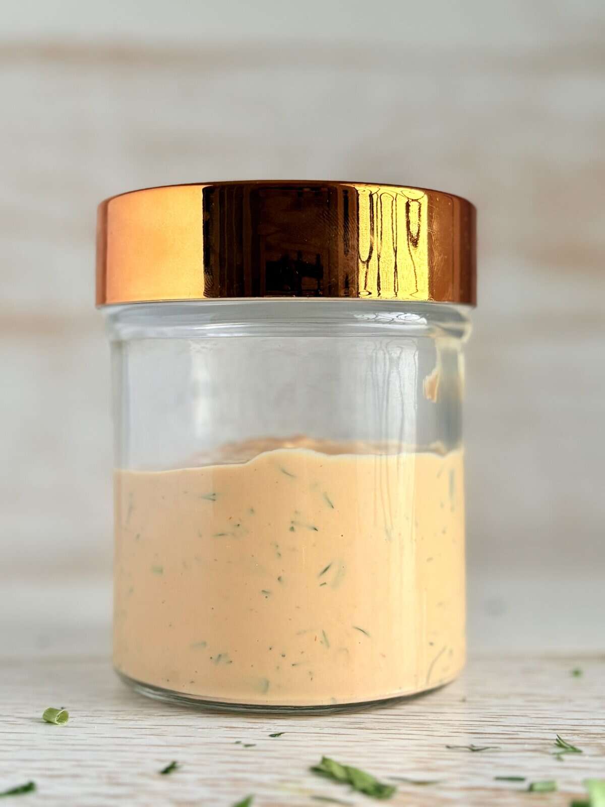 Creamy homemade Russian dressing in a glass jar with a copper lid, perfect for sandwiches and dipping, featuring fresh herbs blended into a rich, flavorful mayonnaise-based sauce for all your favorite dishes.