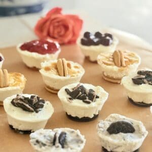 Delicious homemade mini cheesecakes topped with various flavors like chocolate, caramel, and Oreo, perfect for dessert or special occasions. An assortment of bite-sized cheesecakes with creamy texture.