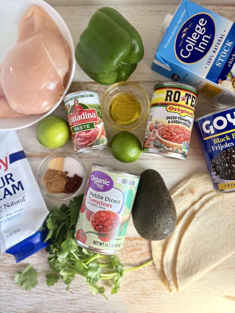 Healthy chicken and vegetable ingredients for nutritious cooking, including chicken breast, green bell pepper, avocado, canned tomatoes, and dairy products.