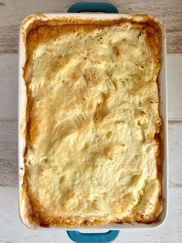 Delicious baked mashed potatoes casserole with golden, crispy top, creamy interior, perfect for family dinners and holiday gatherings. Easy to prepare with butter, cheese, and seasonings.