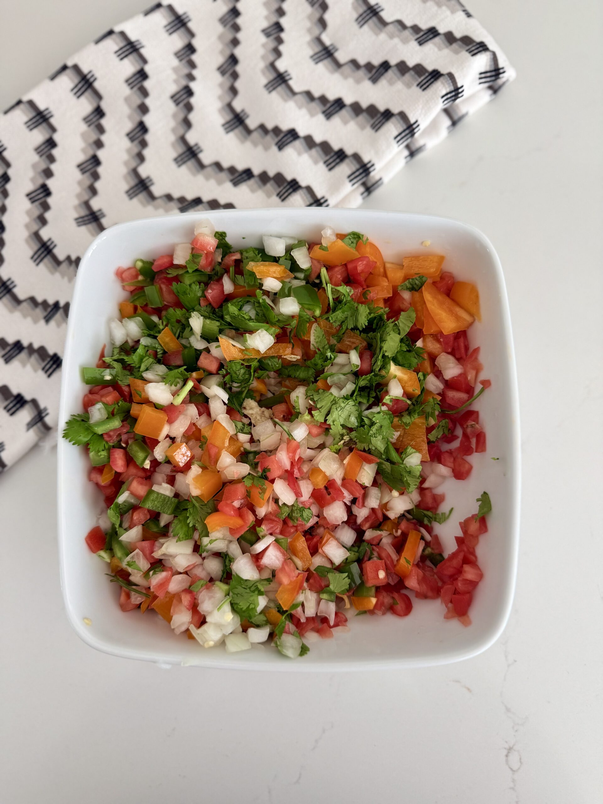 Fresh homemade pico de gallo with diced tomatoes, onions, jalapeños, cilantro, and lime in a white bowl. Perfect for tacos, chips, or as a flavorful topping.