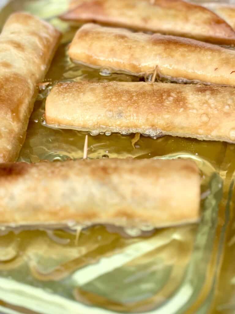 Fried flautas cooking in hot oil, crispy golden exterior, ready to serve.