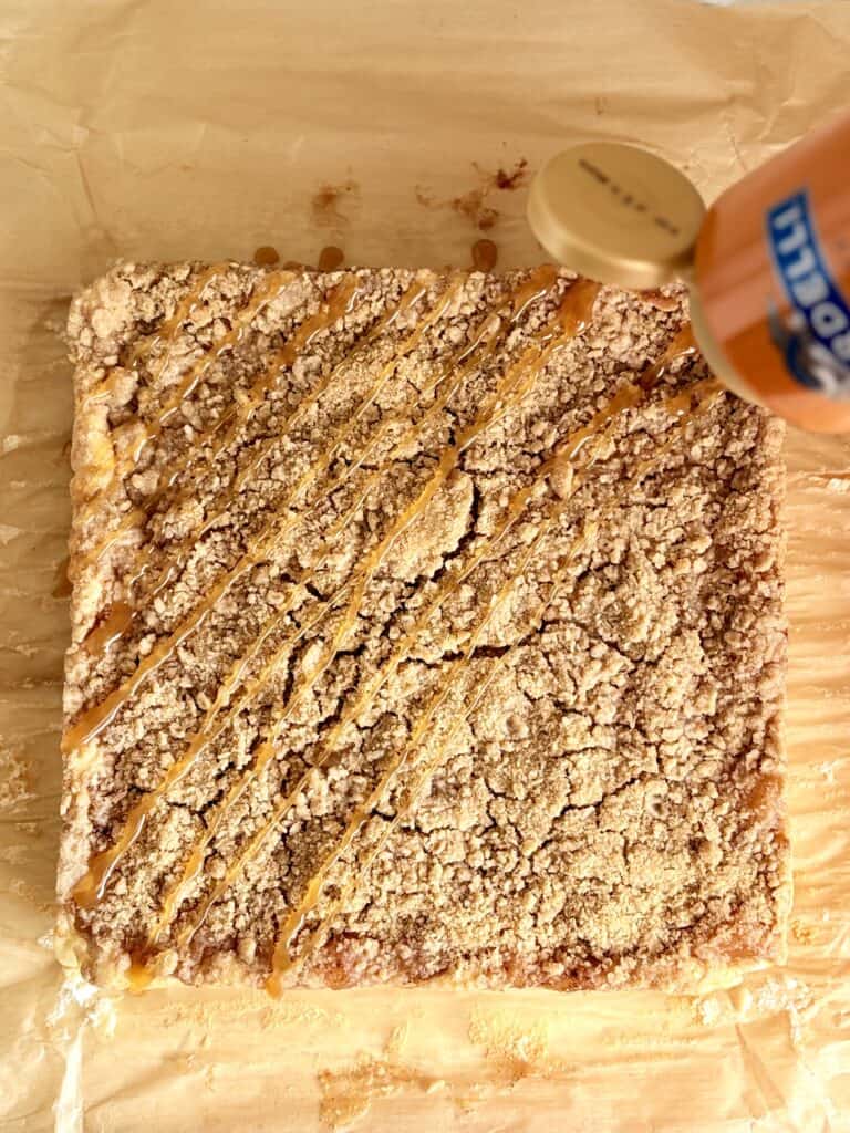 Homemade caramel apple cheesecake bars with a caramel drizzle.