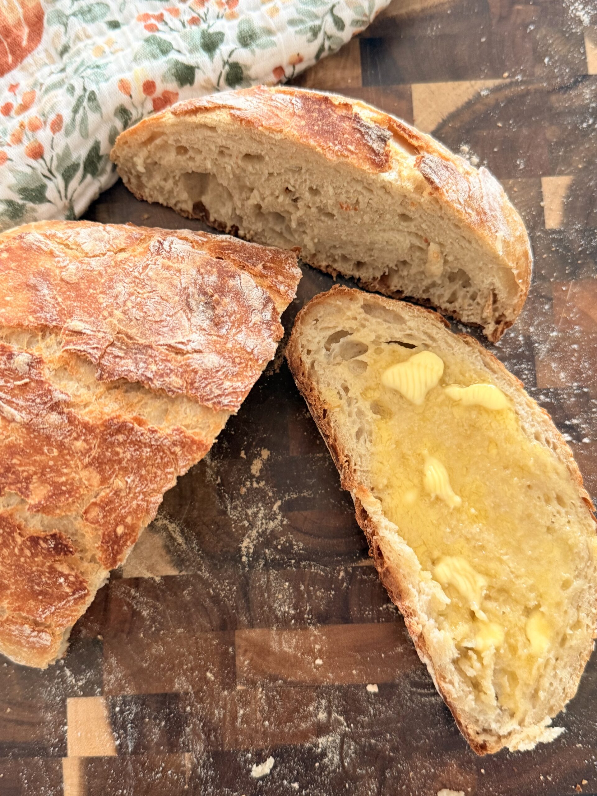 Freshly baked homemade Dutch oven bread with a golden crust and soft interior, perfect for sandwiches or dipping.