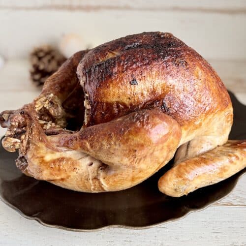 Juicy roasted Turkey with crispy skin served on a black plate, perfect for a hearty meal, from Simply Made Dish.