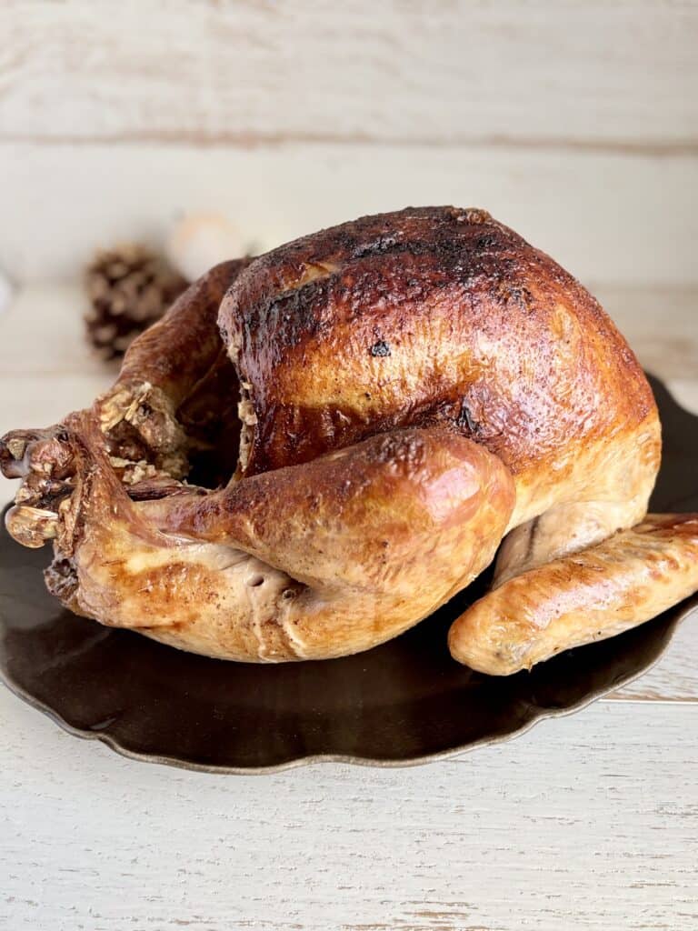 Juicy roasted Turkey with crispy skin served on a black plate, perfect for a hearty meal, from Simply Made Dish.